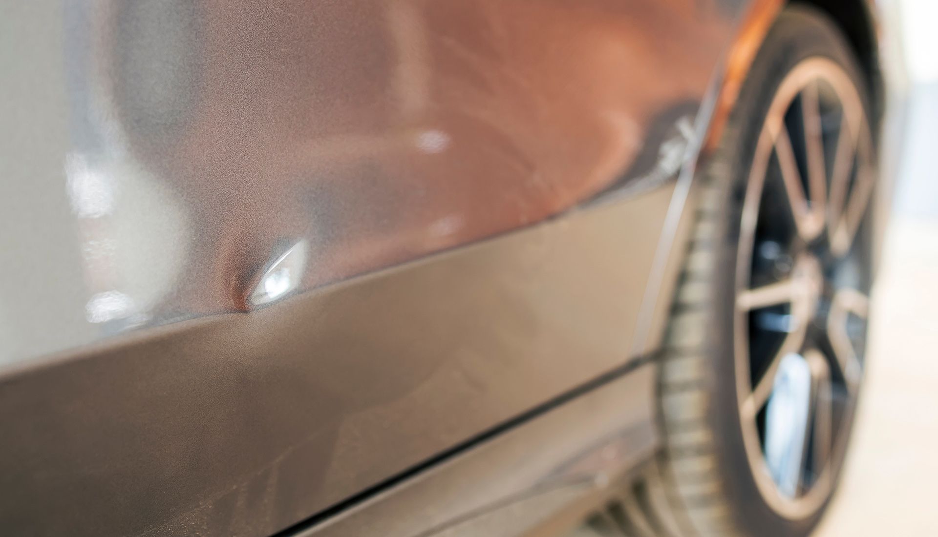 A close up of the side of a car with a scratch on it.