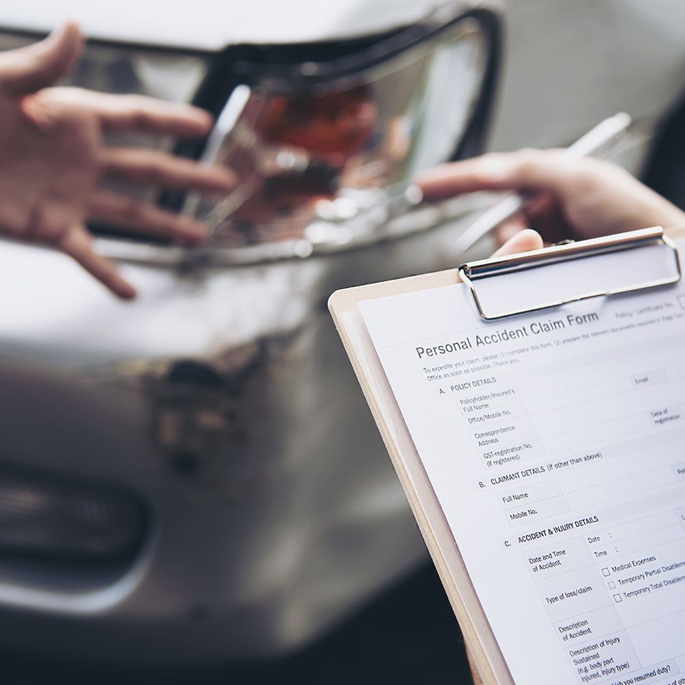A person is holding a clipboard with a form on it in front of a car.
