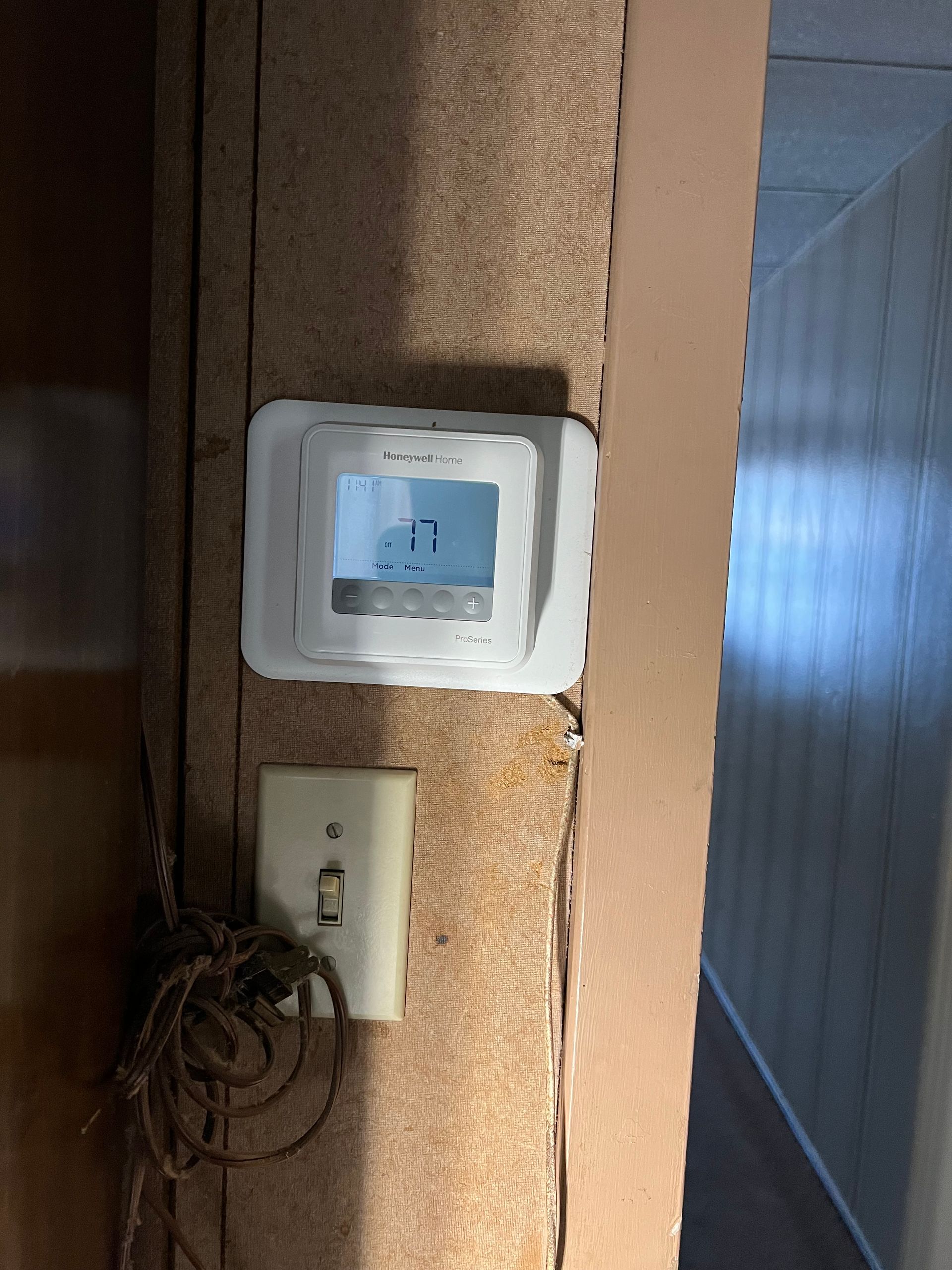 A man and a woman are working on a dishwasher in a kitchen.