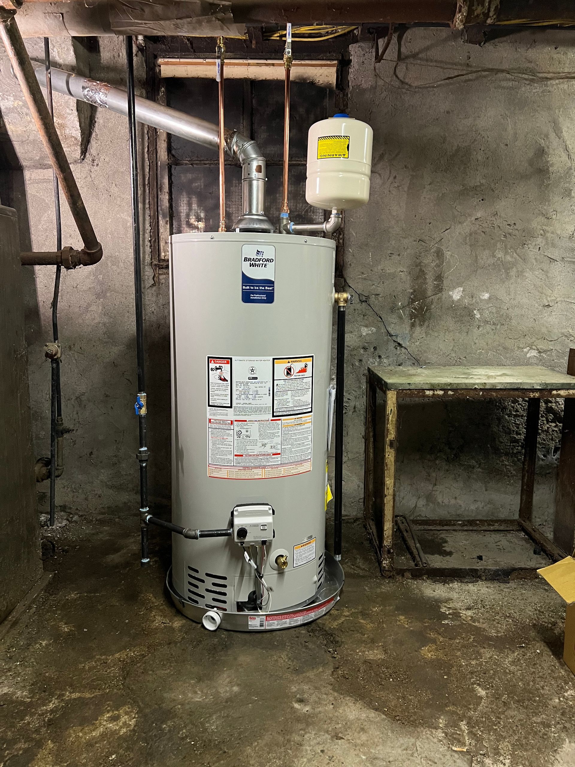 A man wearing a hard hat and safety vest is working on a machine.