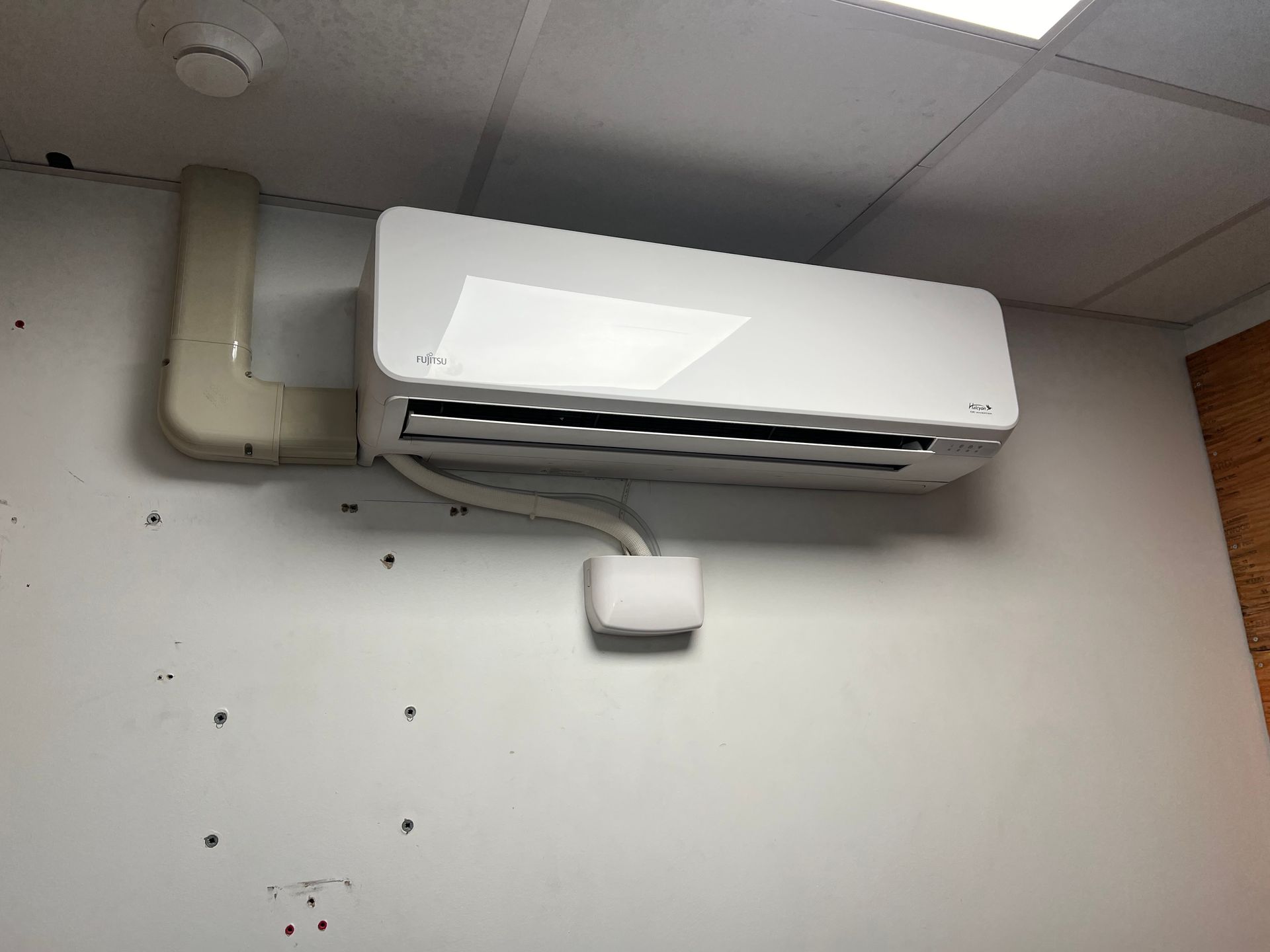 Copper pipes a wrench and fittings are on a table