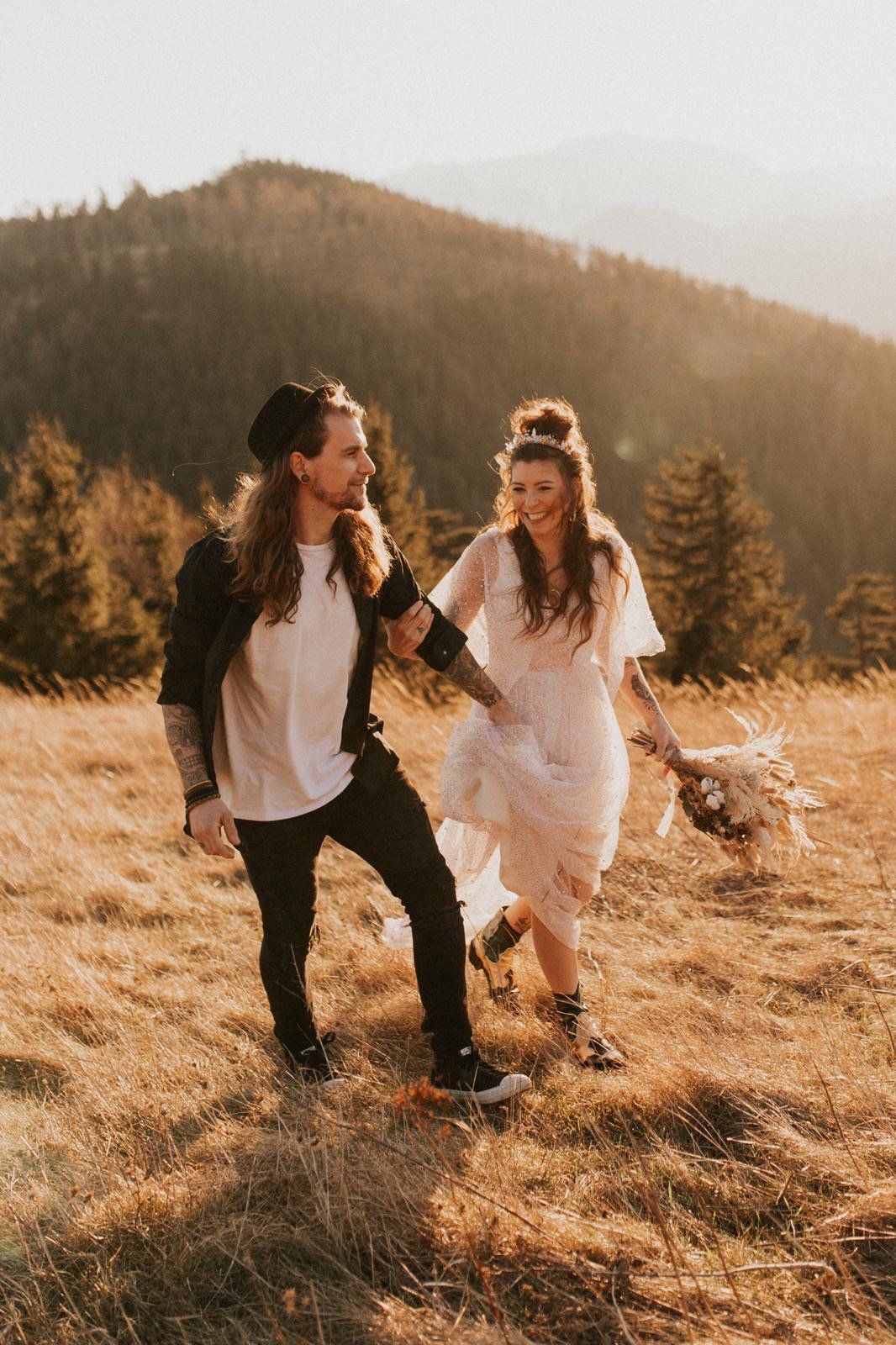Ein Mann und eine Frau halten Händchen und laufen auf einem Feld .