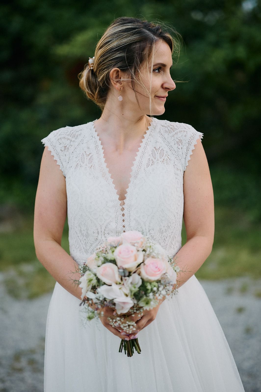 Eine Frau in einem weißen Kleid hält einen Blumenstrauß.
