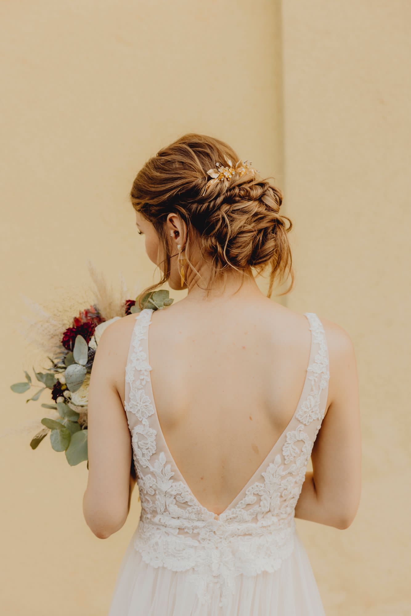 Eine Frau in einem Brautkleid hält einen Blumenstrauß.