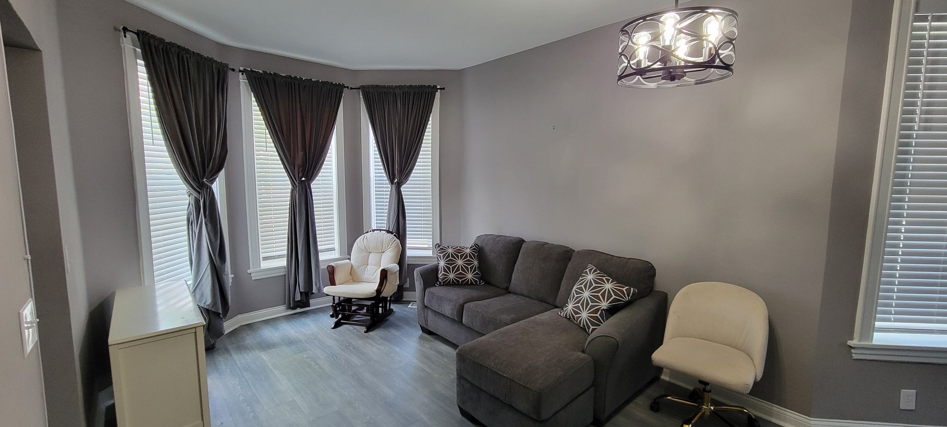 A living room with a couch , chair , and chandelier.