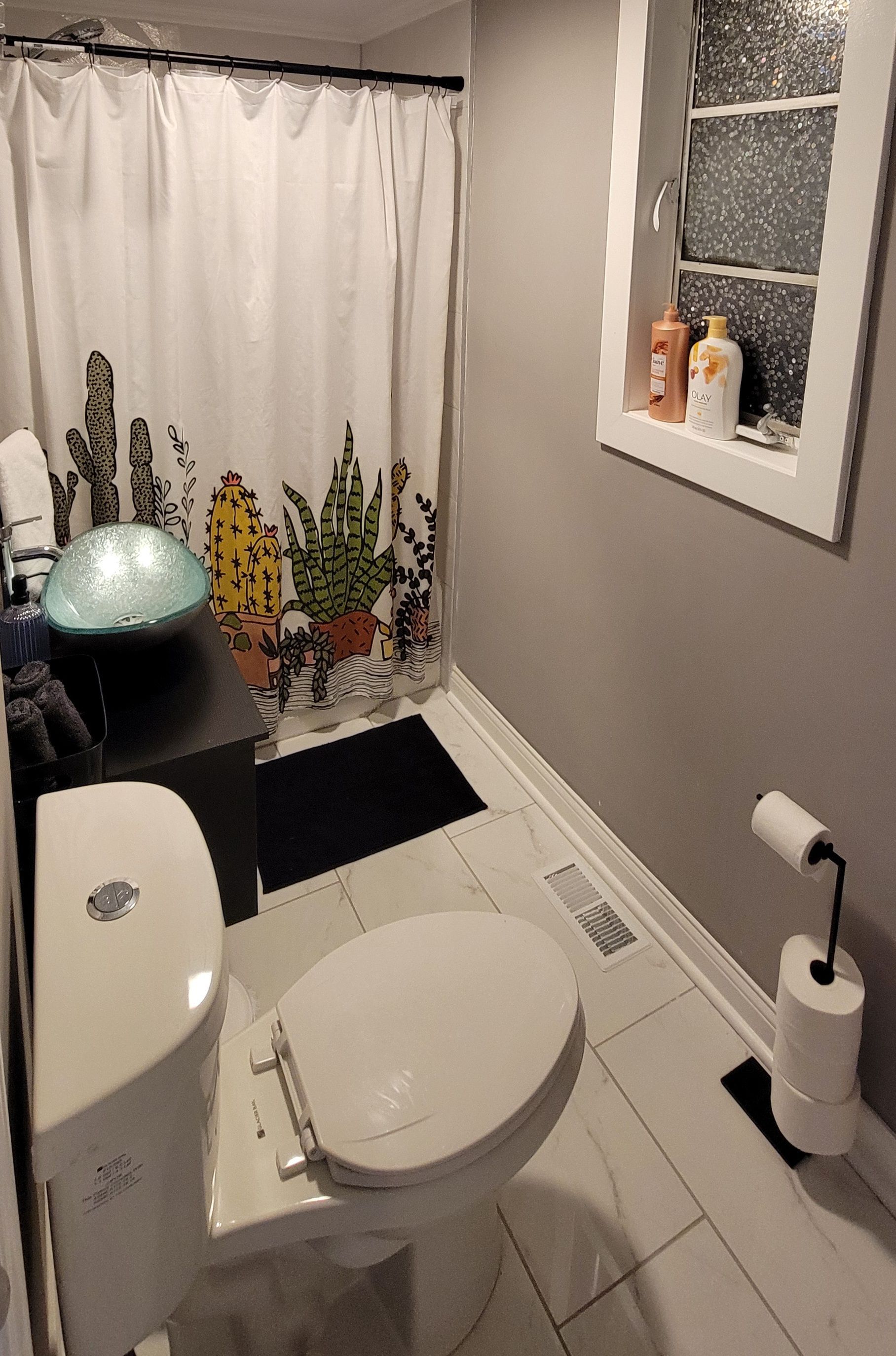 A bathroom with a toilet , sink , and shower curtain.