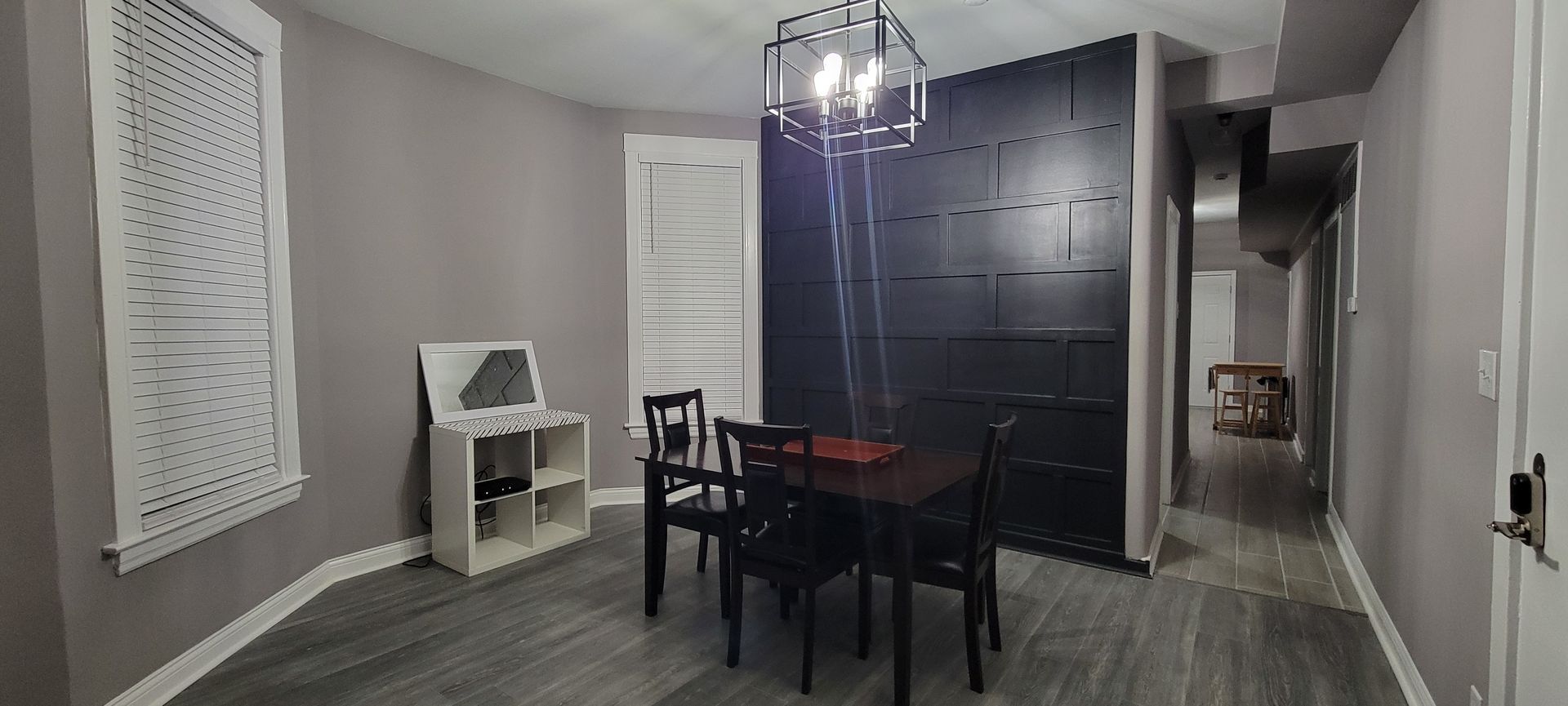 A dining room with a table and chairs and a chandelier.