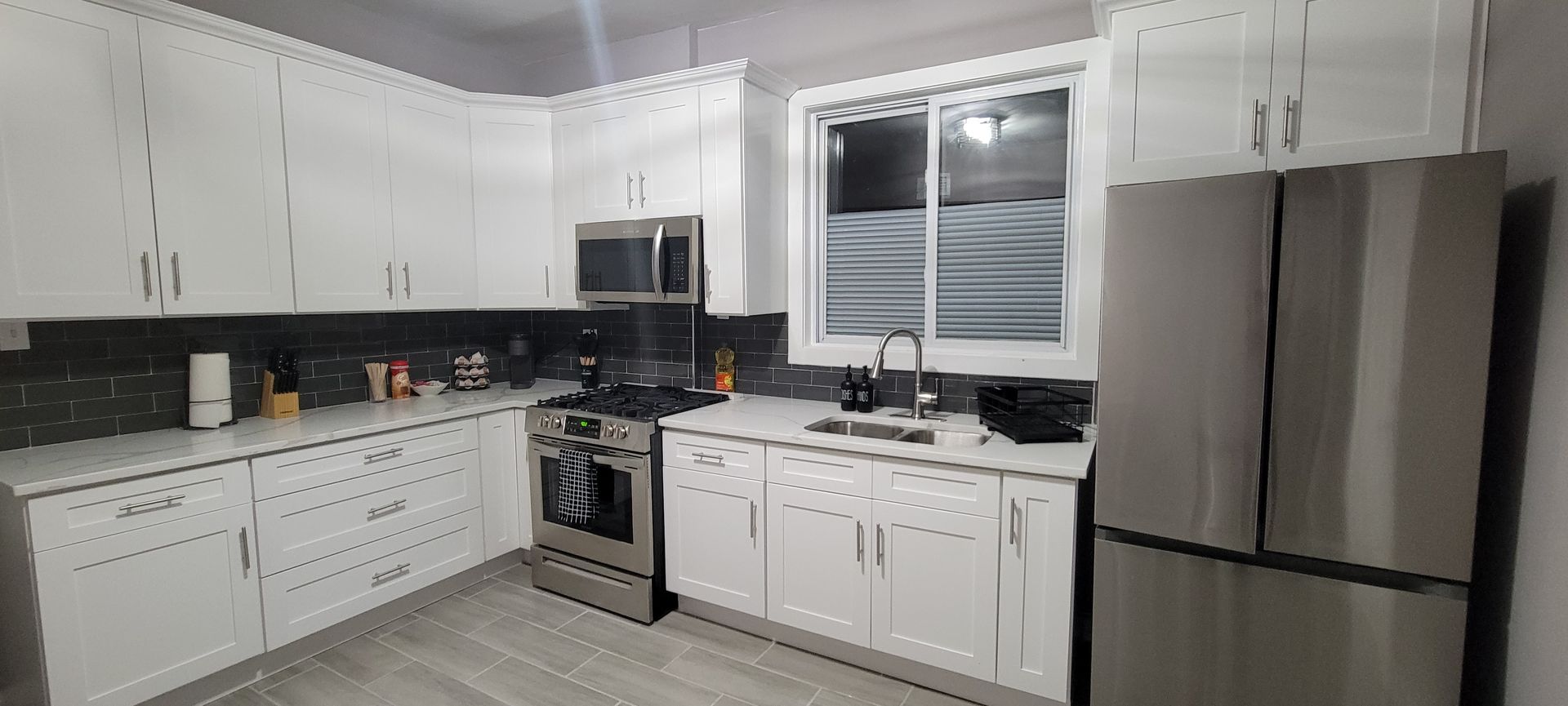 A kitchen with white cabinets and stainless steel appliances.