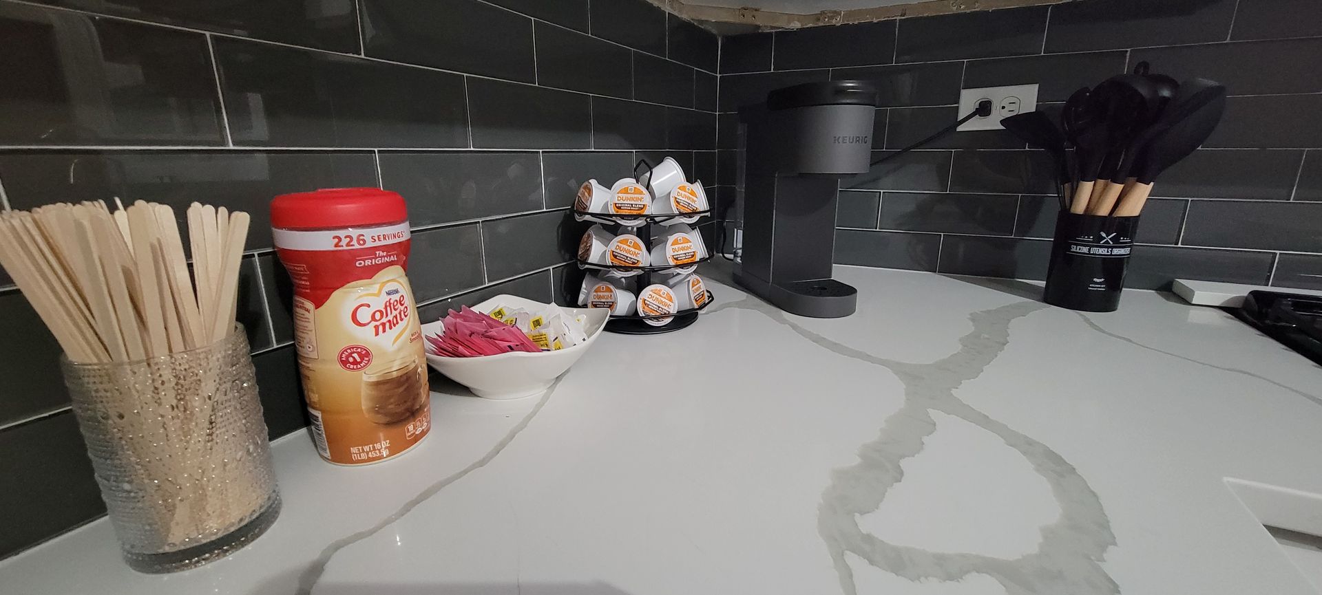 A kitchen counter with a bowl of food and a jar of spices.