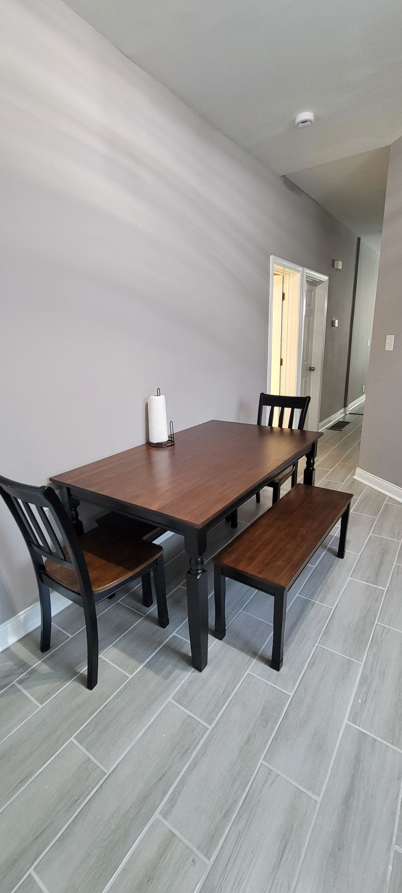 A dining room with a table and chairs and a bench.