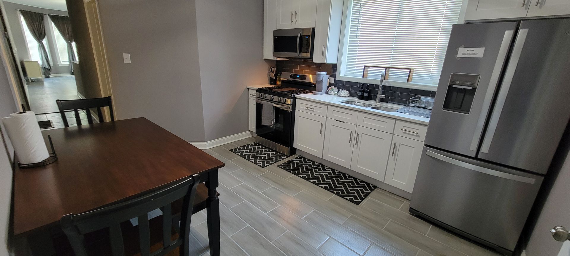 A kitchen with a table and chairs and a refrigerator.