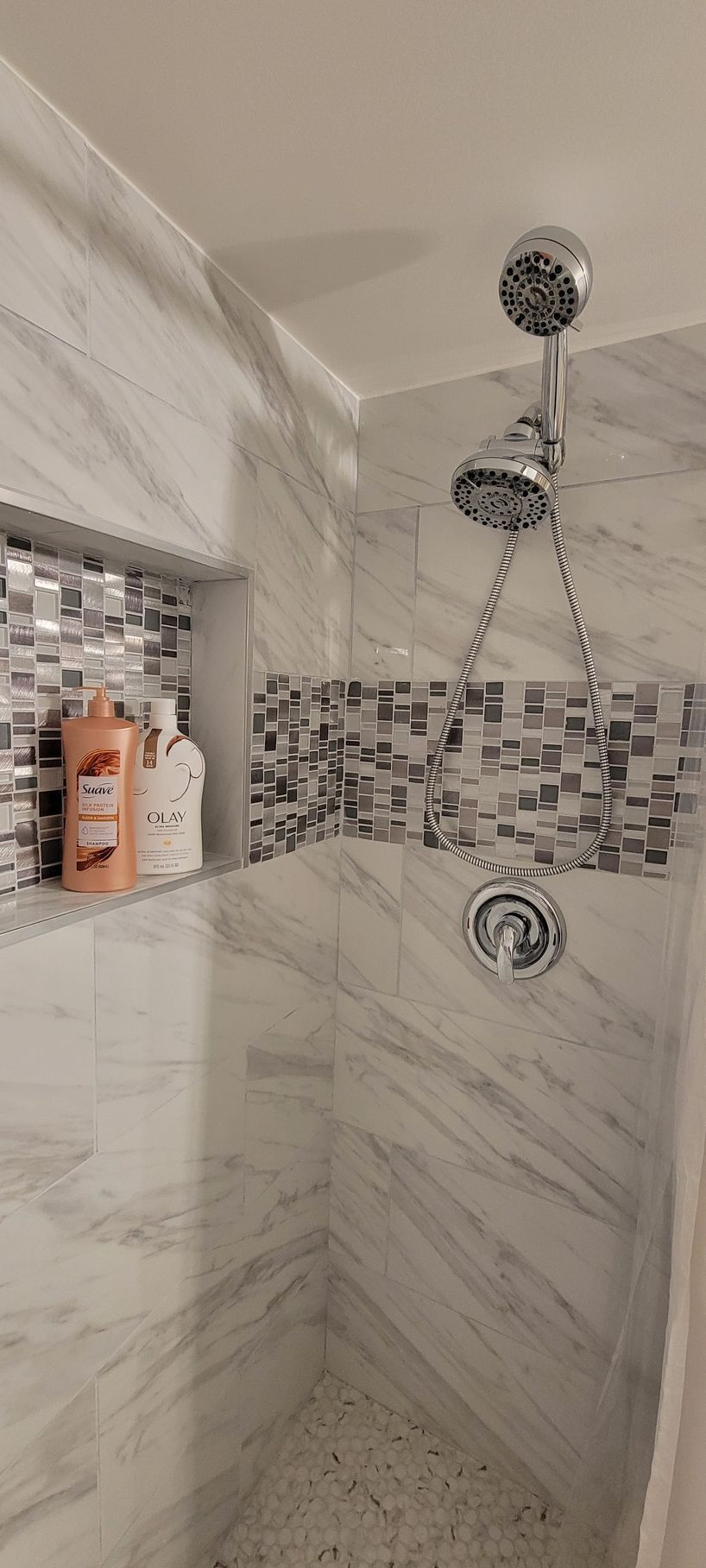 A shower with three shower heads and a soap dispenser.