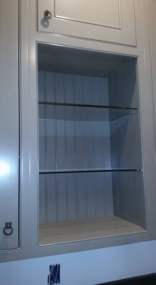A kitchen cabinet with a glass shelf built into it.