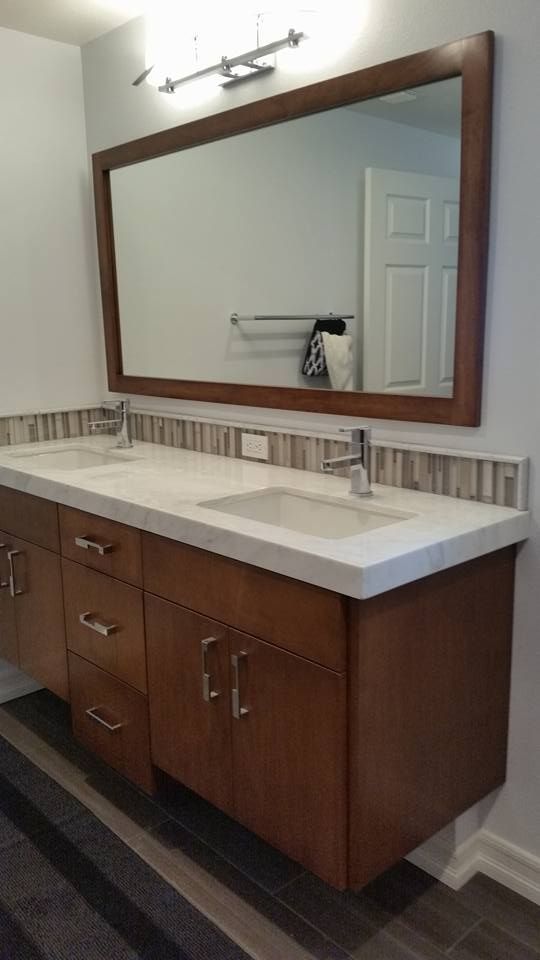A bathroom with two sinks and a large mirror.