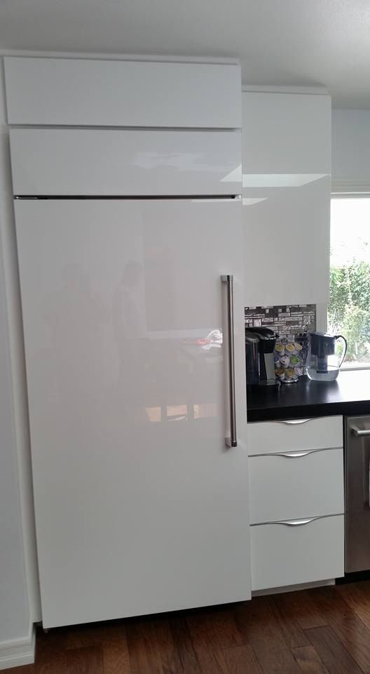 A large white refrigerator is sitting in a kitchen next to a counter.