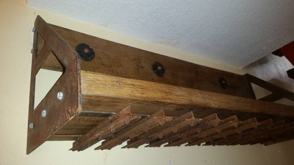 A wooden wine rack is hanging on a wall.