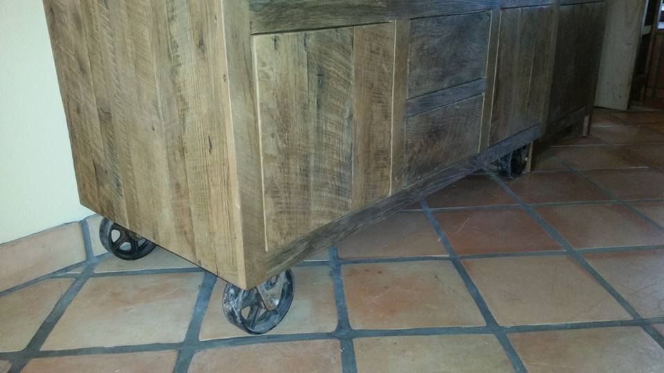 A wooden cabinet with wheels is sitting on a tiled floor.