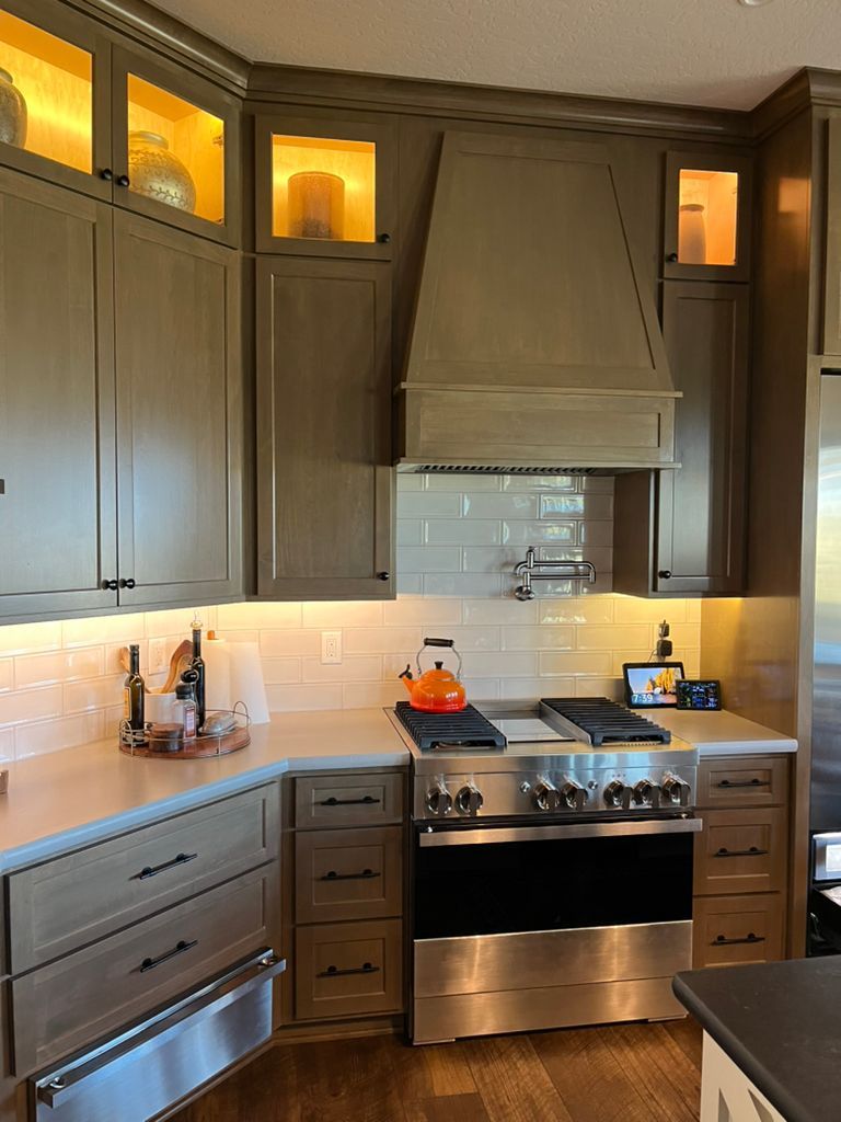A kitchen with stainless steel appliances and gray cabinets