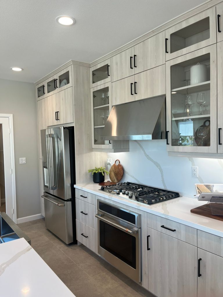 A kitchen with stainless steel appliances and white cabinets.