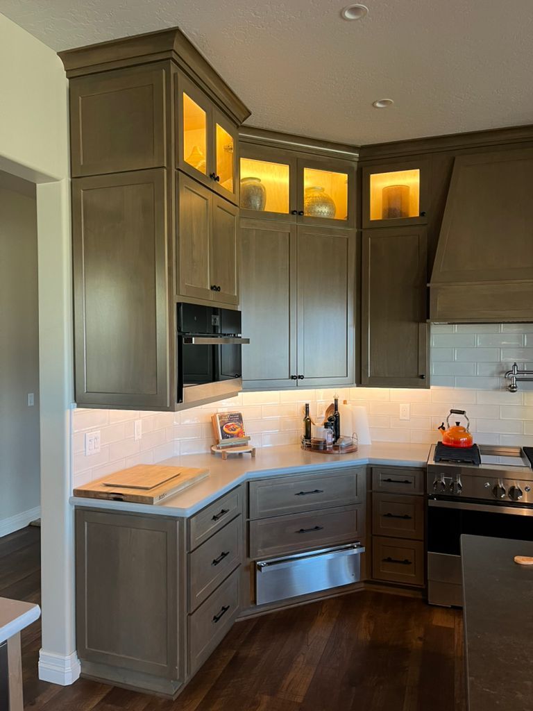 A kitchen with gray cabinets and stainless steel appliances