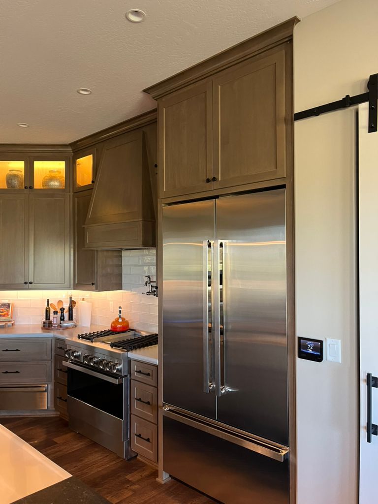 A kitchen with a stainless steel refrigerator and stove.