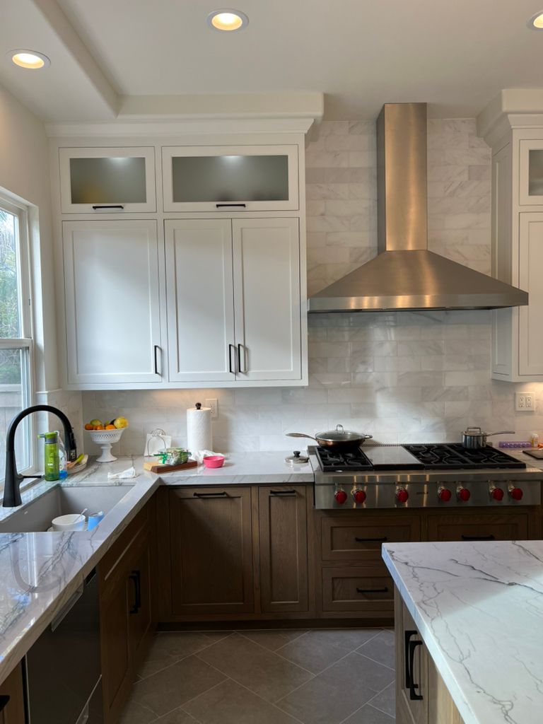 A kitchen with stainless steel appliances and white cabinets.