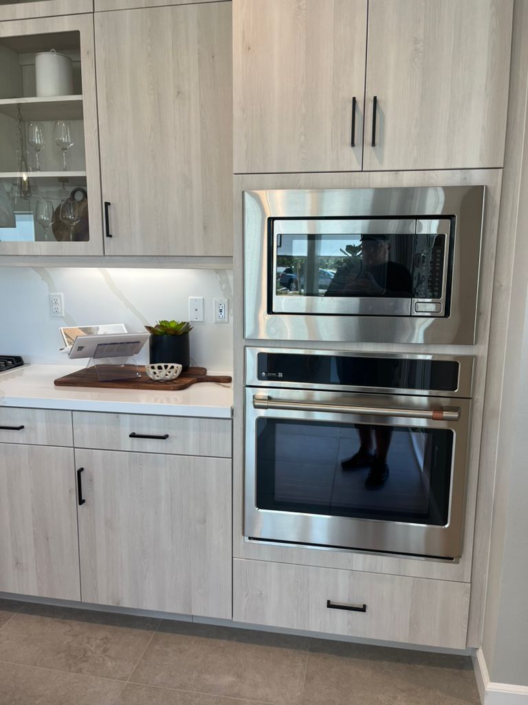 A kitchen with stainless steel appliances and white cabinets