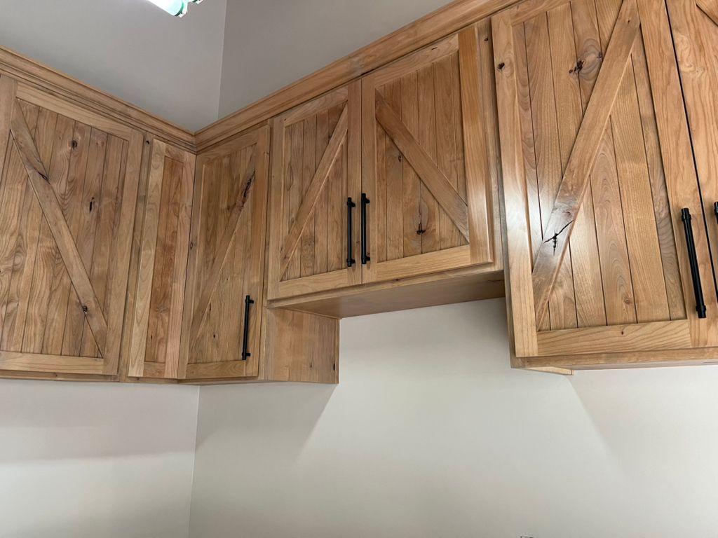 A kitchen with wooden cabinets and a stove hood.