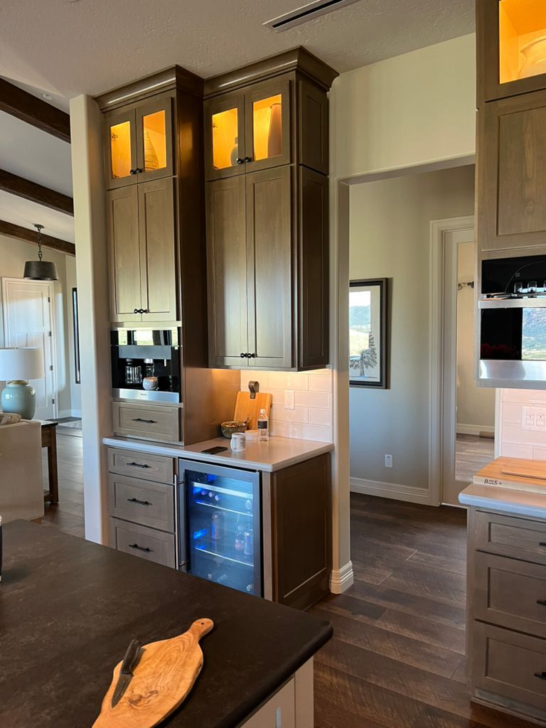 A kitchen with a refrigerator and a cutting board on the counter.