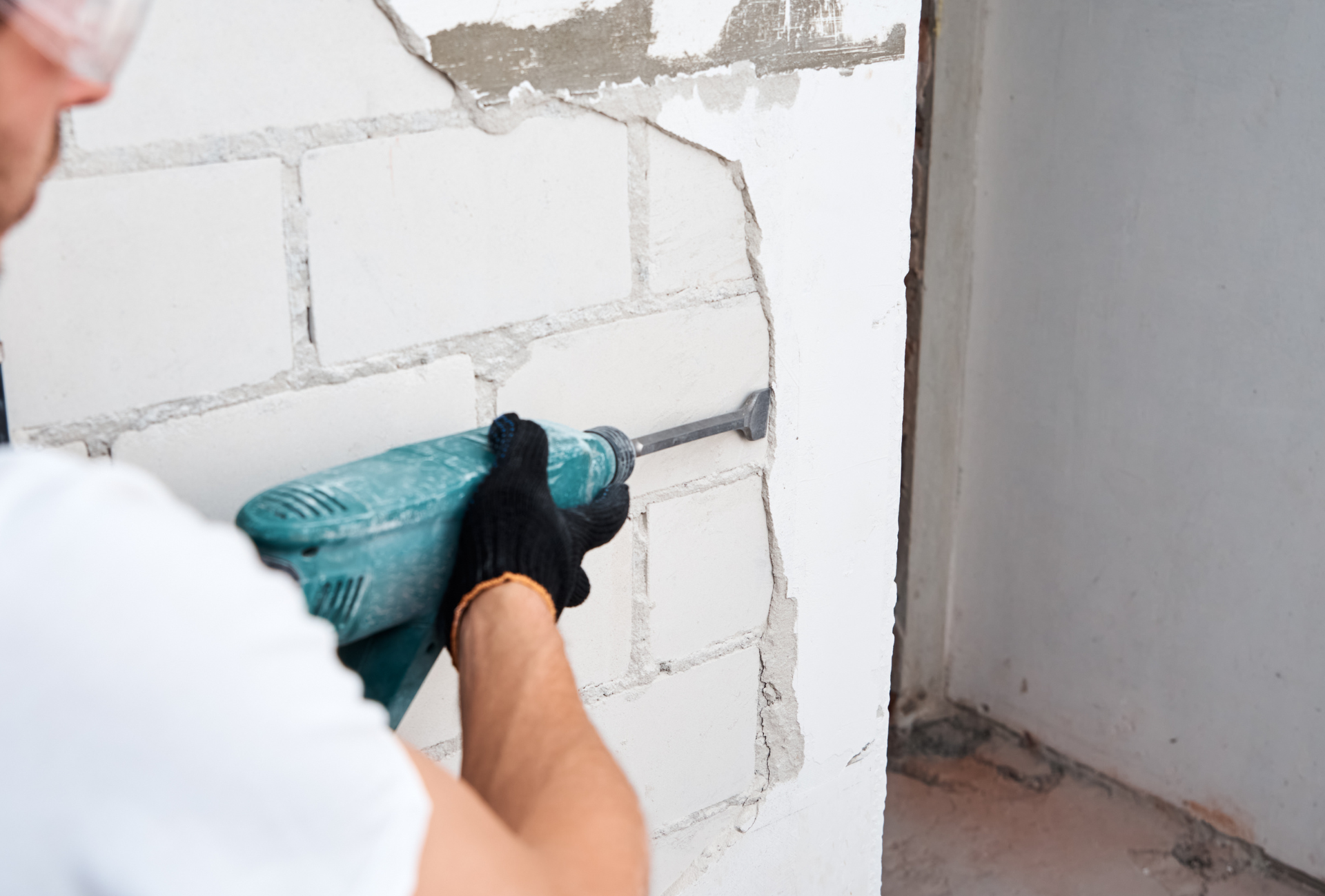 A man is using a drill to drill a hole in a wall.