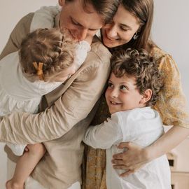 A man and woman are holding two children in their arms.