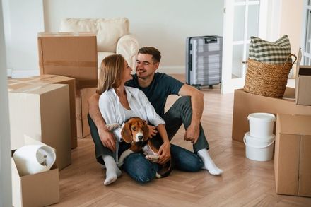 A man and a woman are sitting on the floor with a dog.