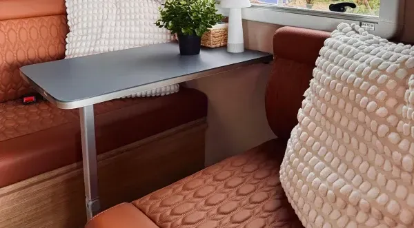 Ein Tisch in einem Wohnmobil mit braunen, strukturierten Sitzen