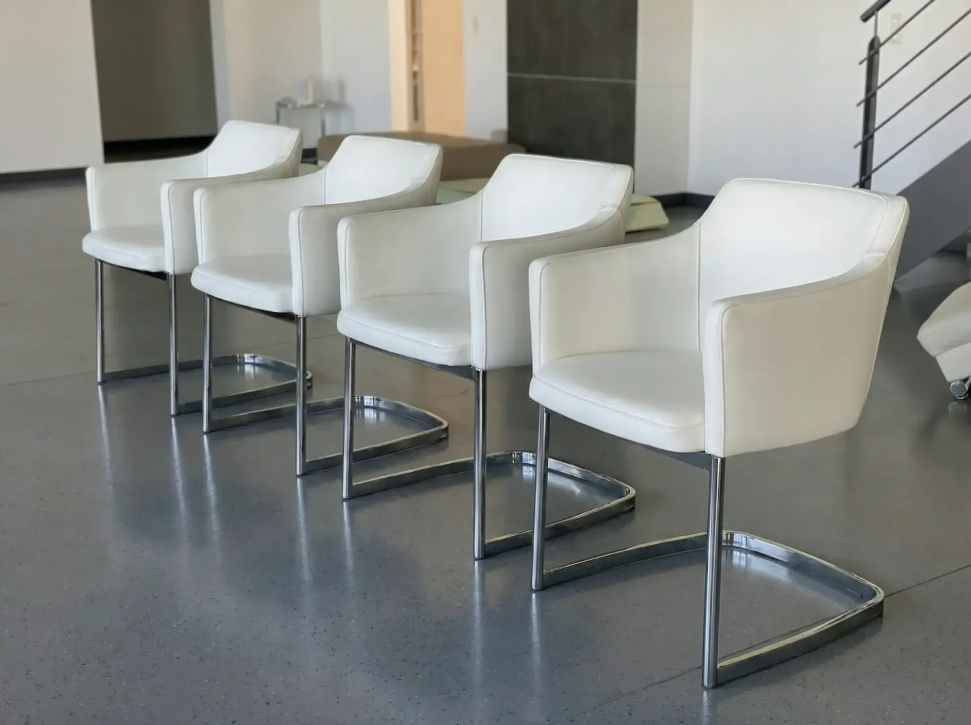 Vier weiße, moderne Sessel mit verchromten Freischwingerfüßen 