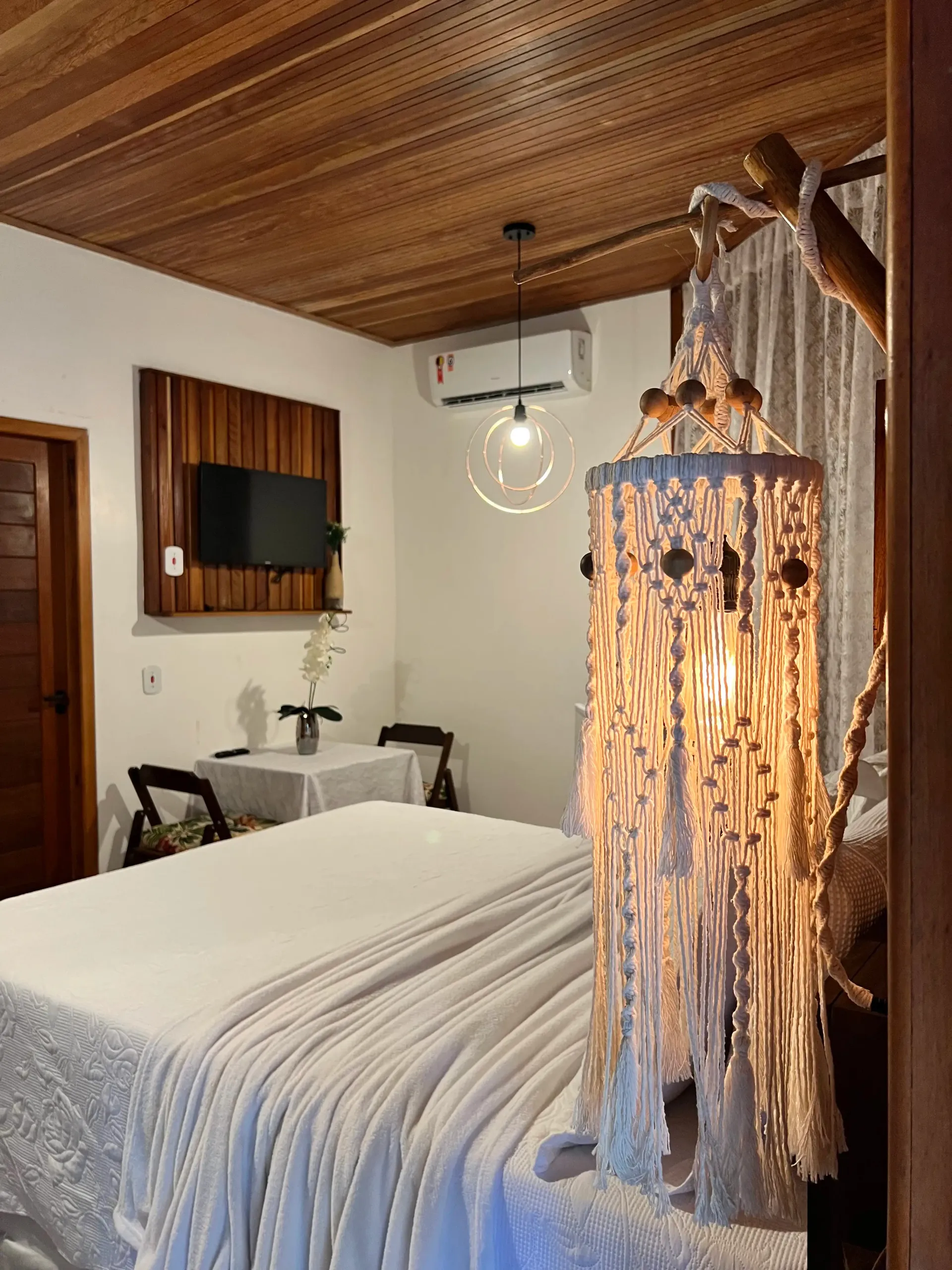 Um quarto com uma cama, mesa, cadeiras e um abajur. Pousada-Sumaúma