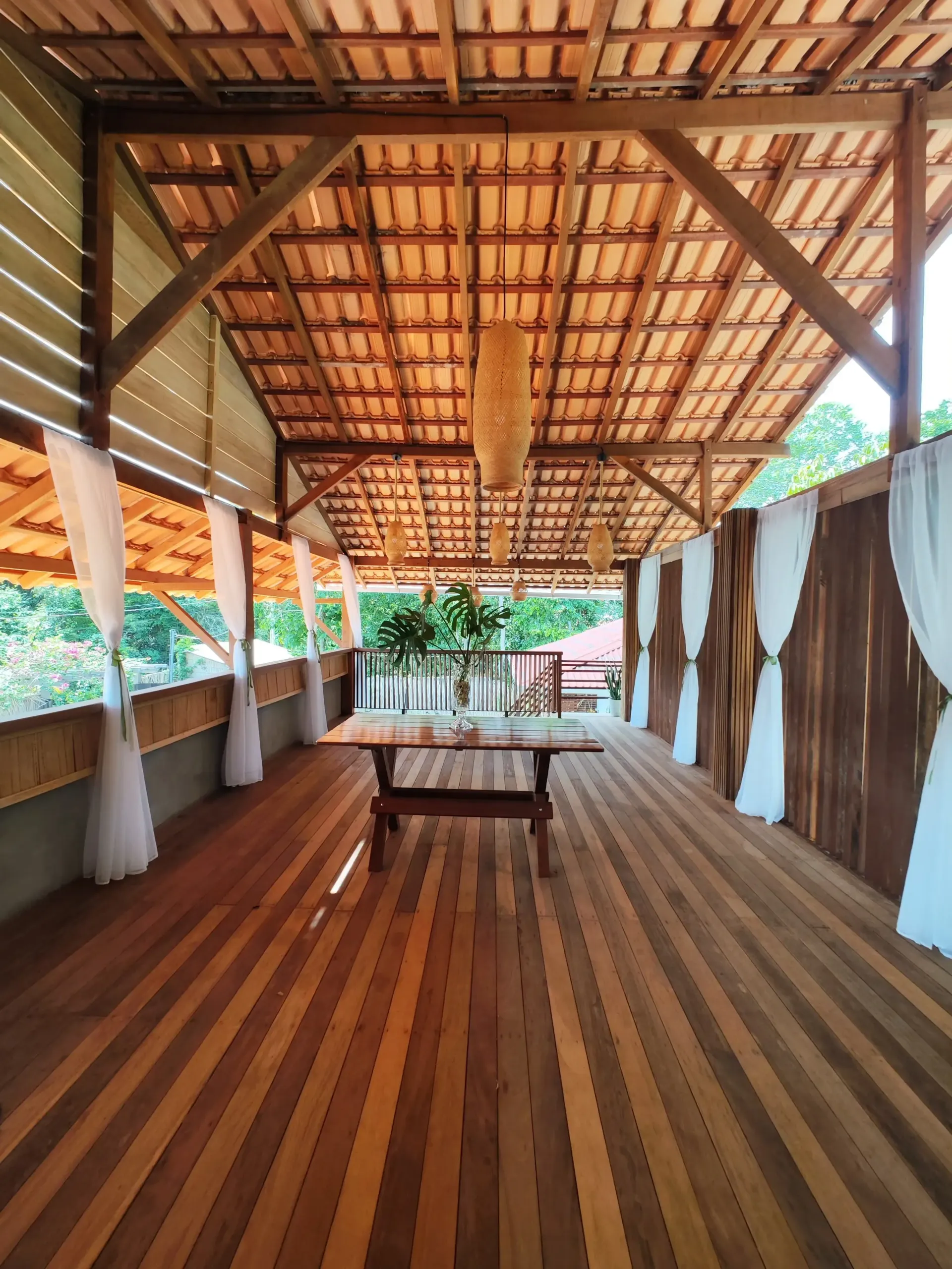 Há uma mesa de madeira no meio da sala.