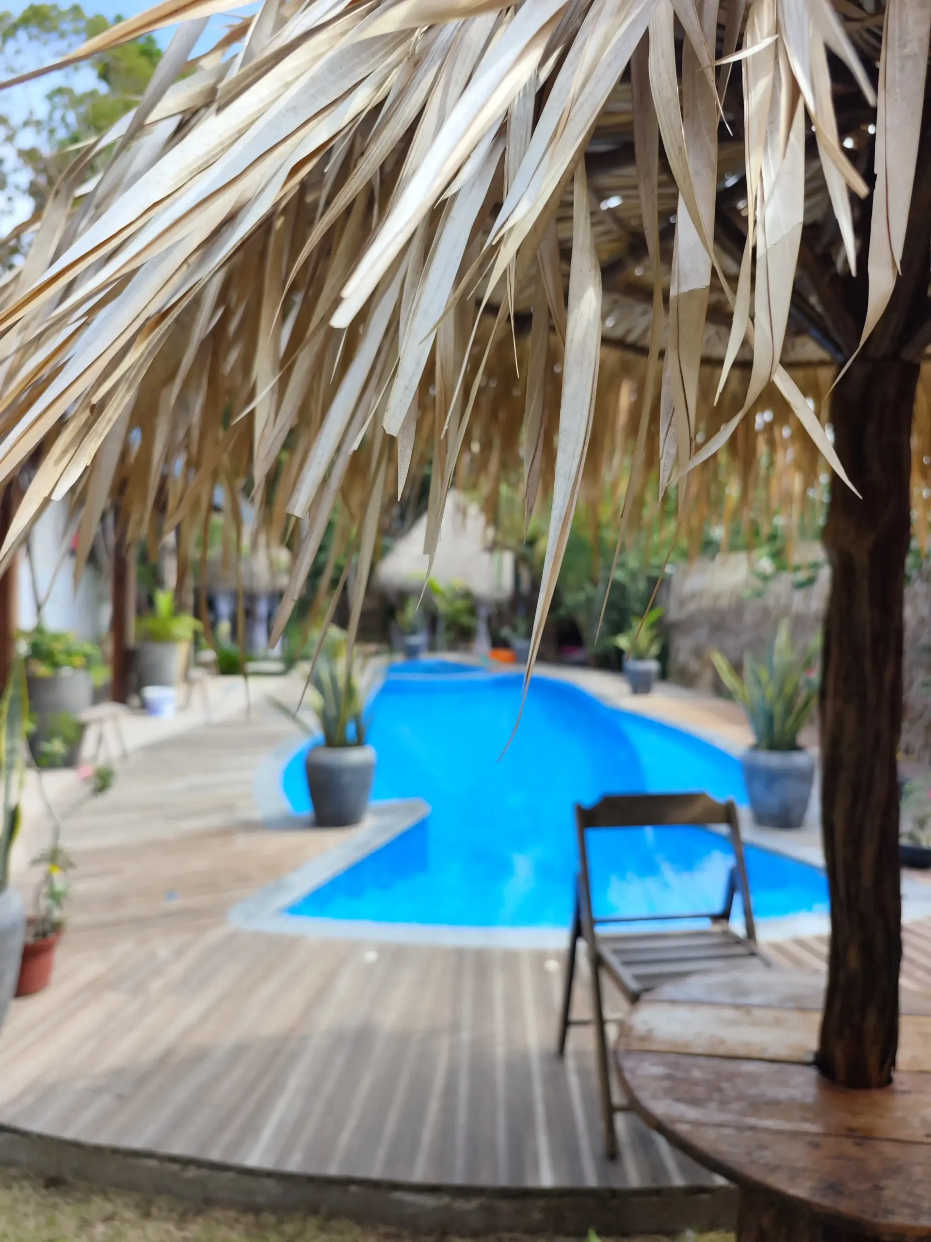Uma piscina com uma mesa e cadeiras sob um guarda-sol. Pousada-Sumaúma