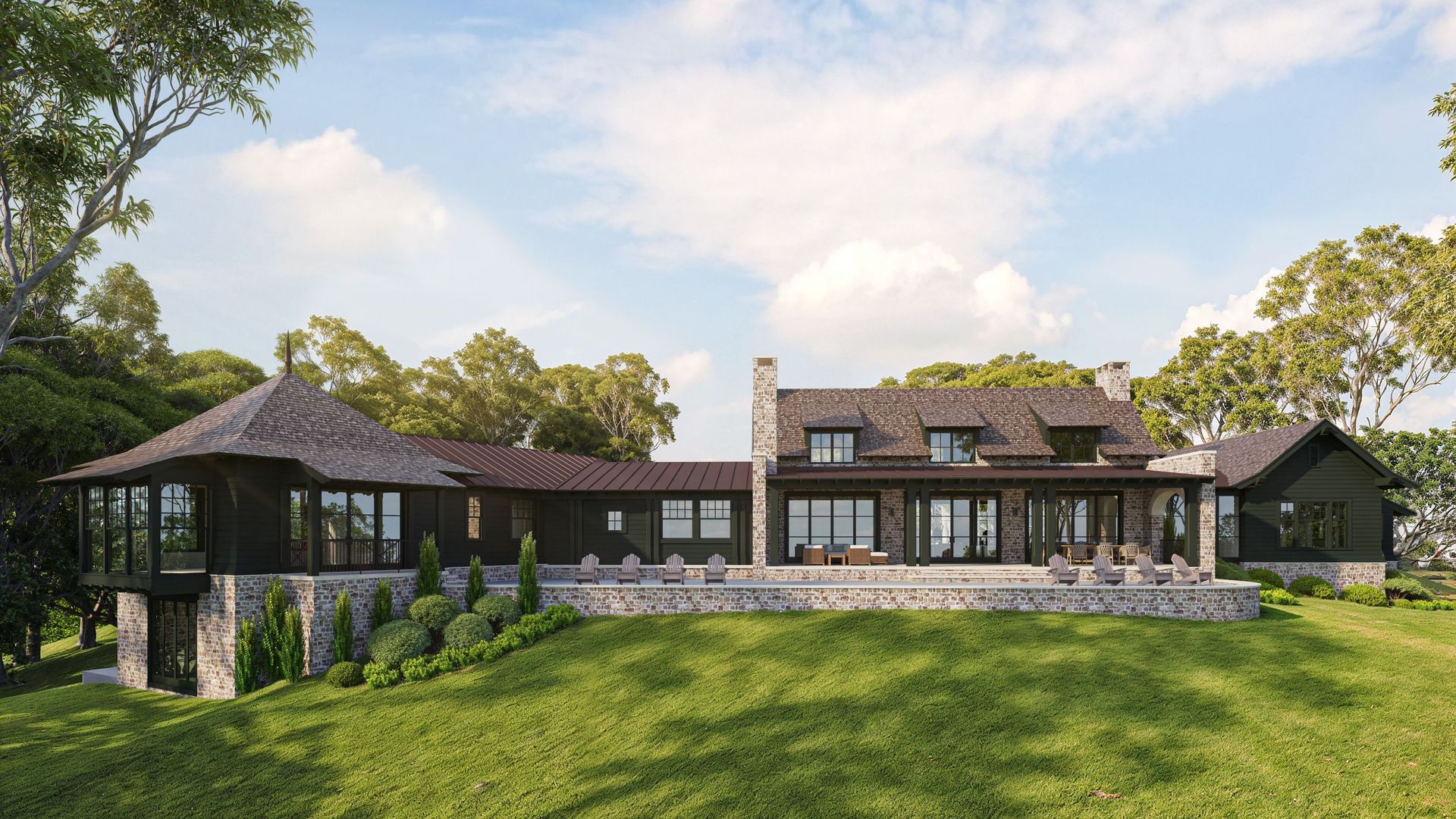 Modern dark home with stone base and glass doors, set on a green hill with trees.