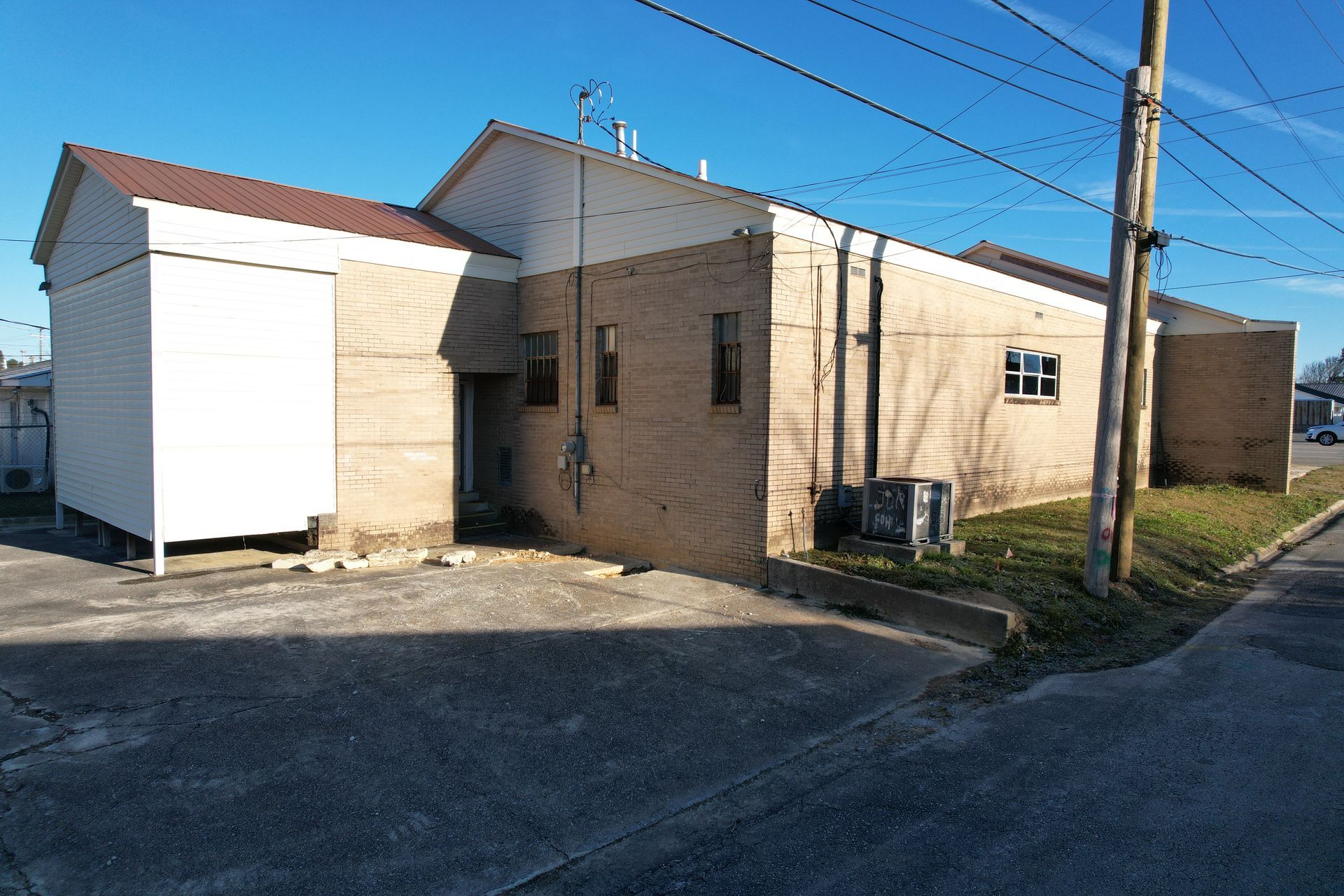 Brick building exterior with brown roof, blue sky backdrop.