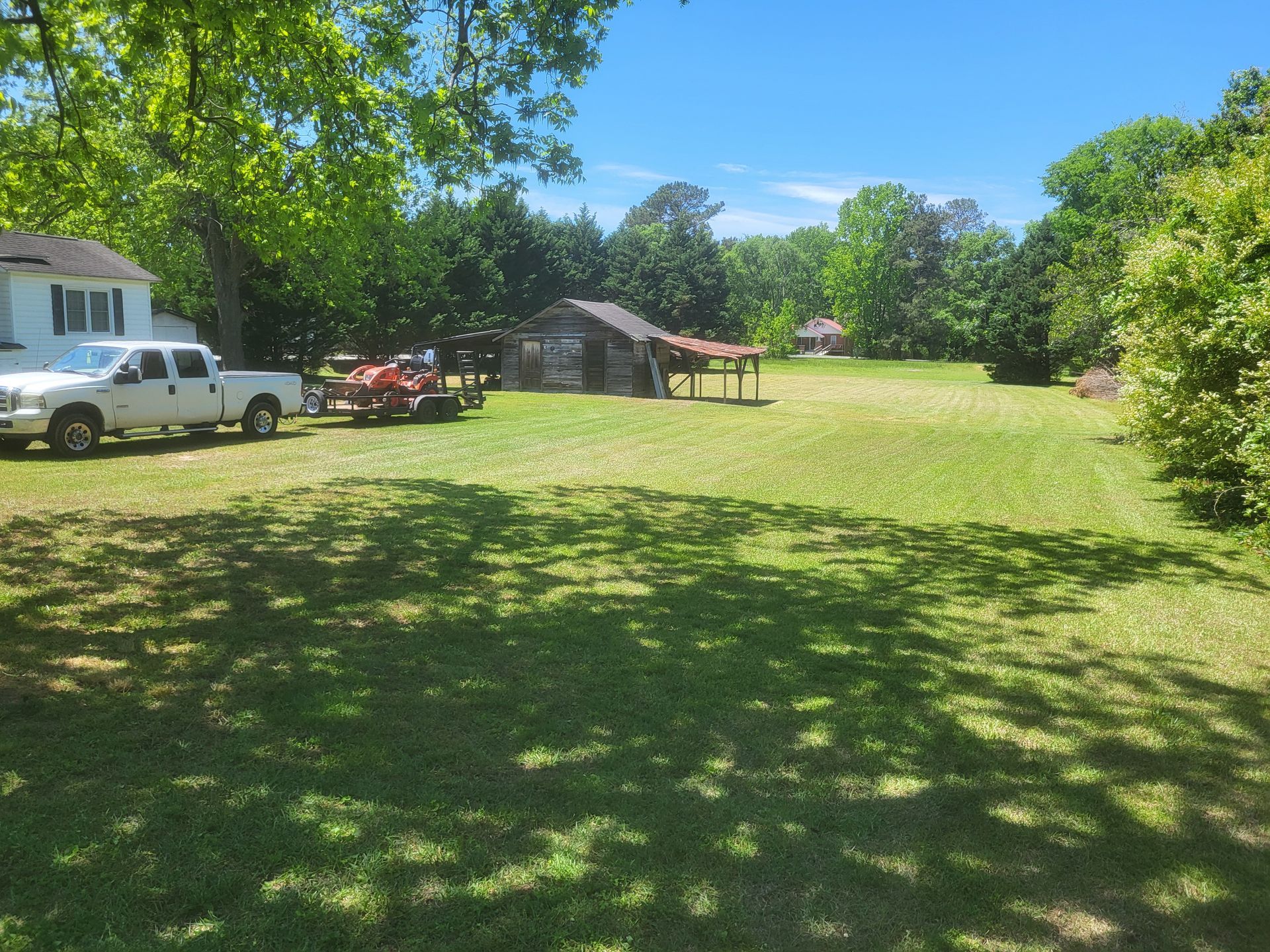 A white truck is parked in a grassy field next to a horse.