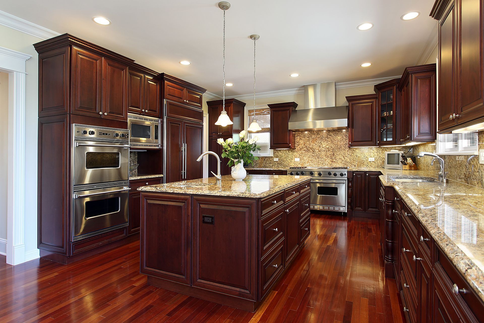 Elegant kitchen with dark wood cabinets, granite countertops, and stainless steel appliances.