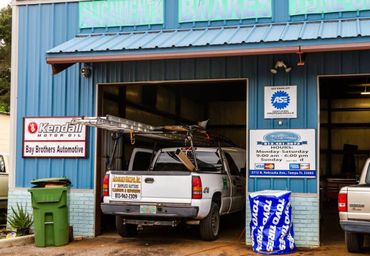 A white truck is parked in front of a blue building