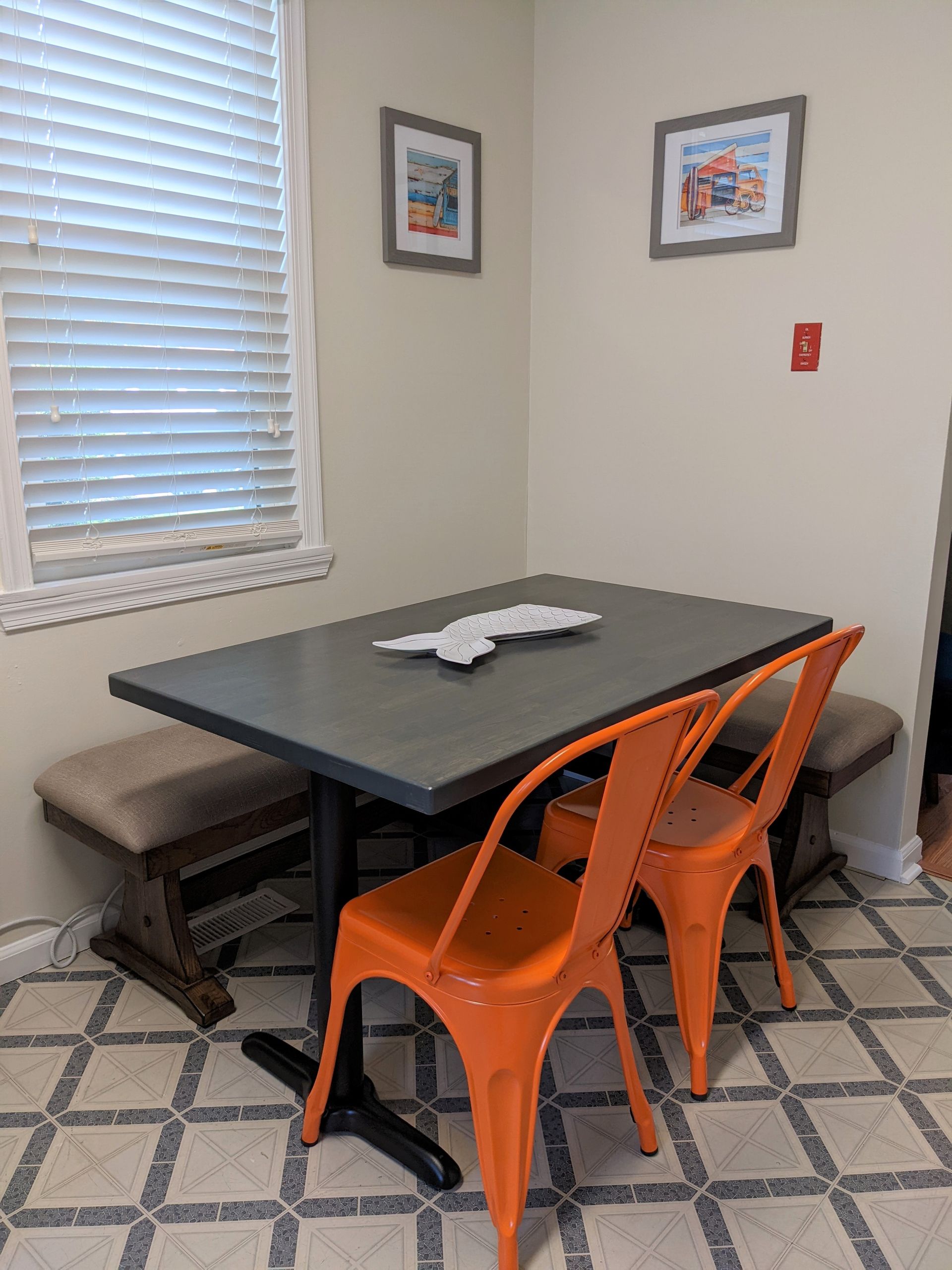 A dining room table with orange chairs and a bench