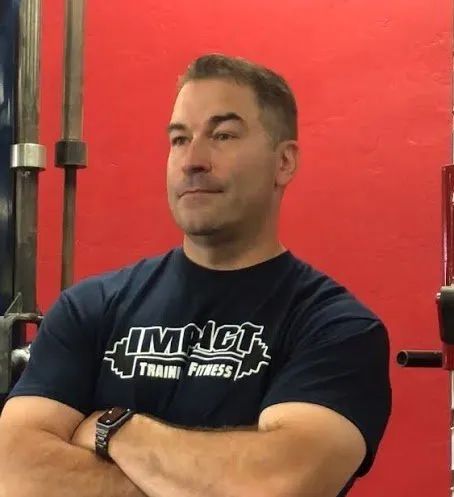 a man wearing a blue shirt that says impact on it