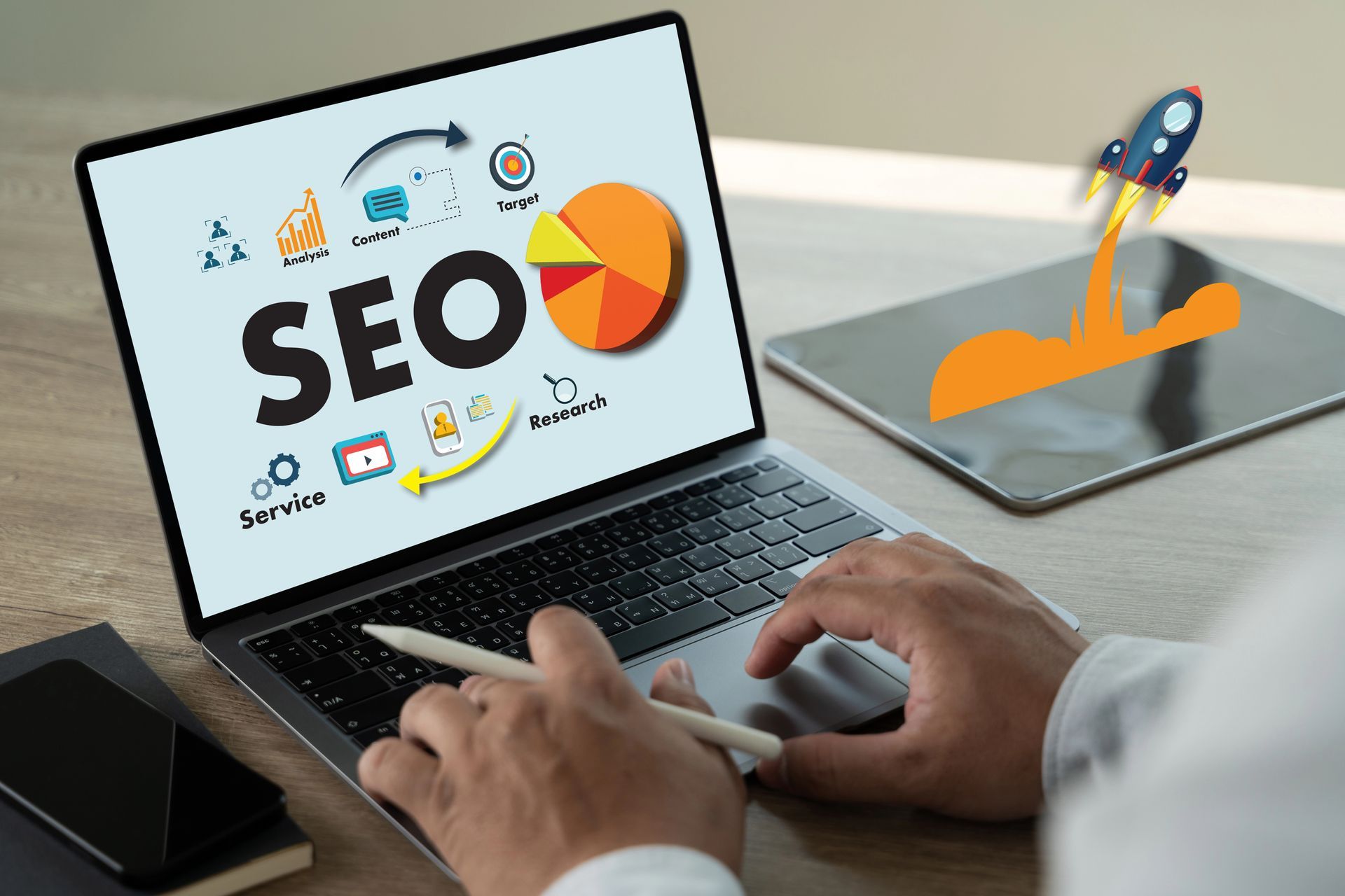 Person typing on laptop showing SEO graphics, with digital marketing icons on screen and a rocket launch illustration