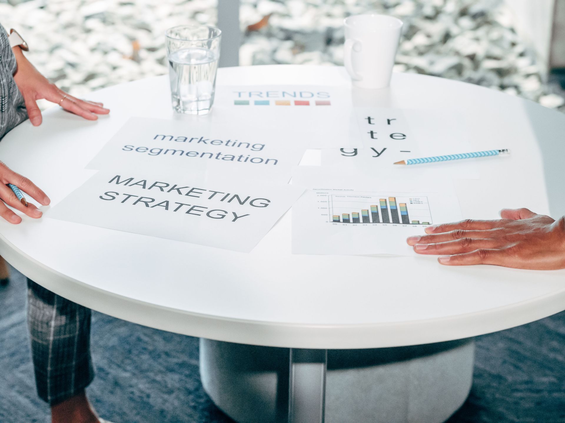Card labeled “marketing segmentation” on a desk with scattered notes and a clipboard, shallow focus.