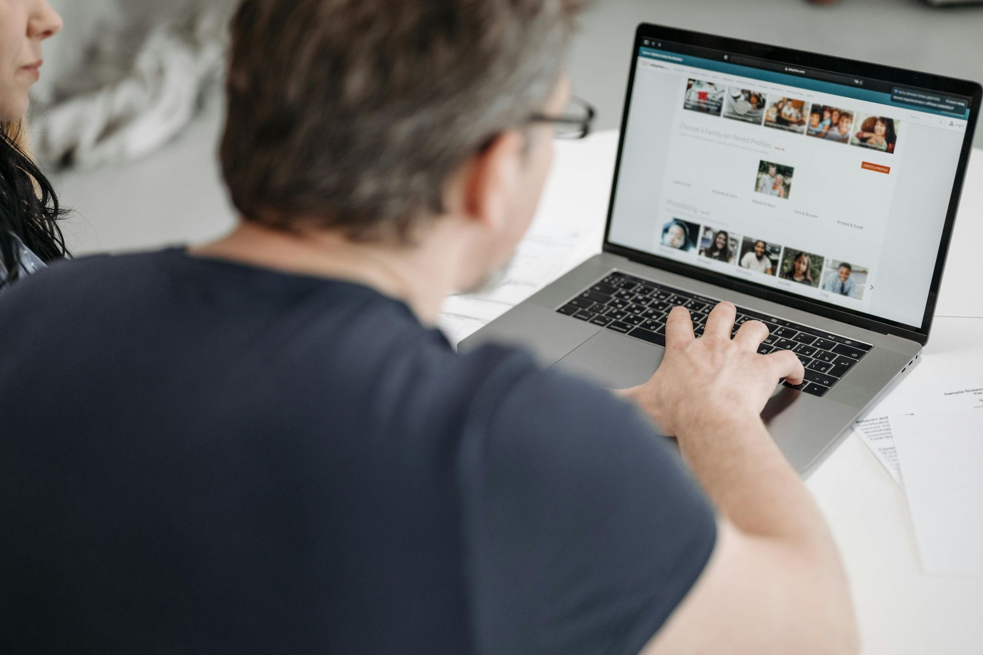 A man and a woman are looking at a laptop computer.