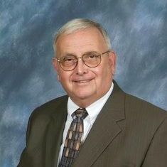 A man in a suit and tie is smiling for the camera.