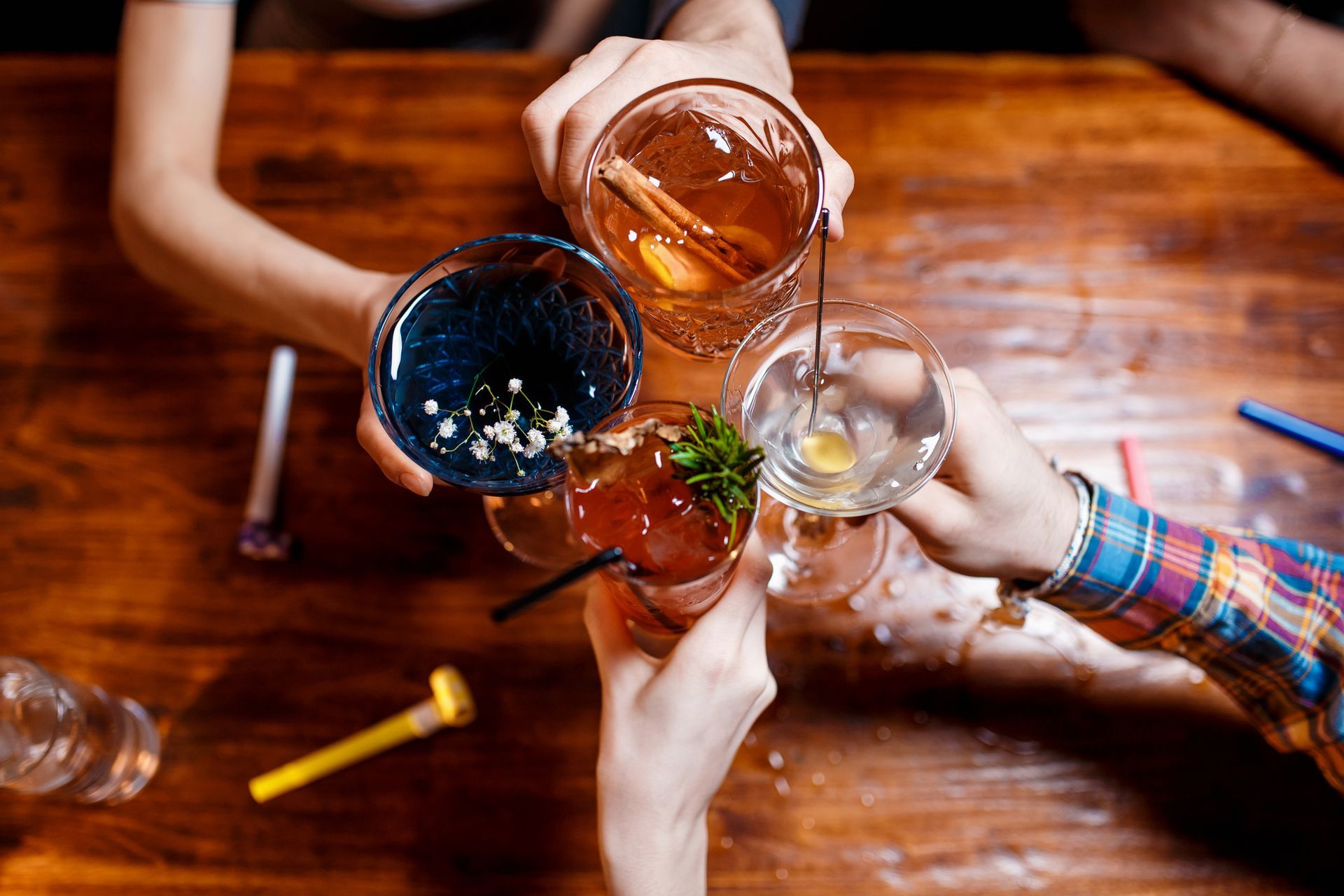A group of people are toasting with drinks at a table.