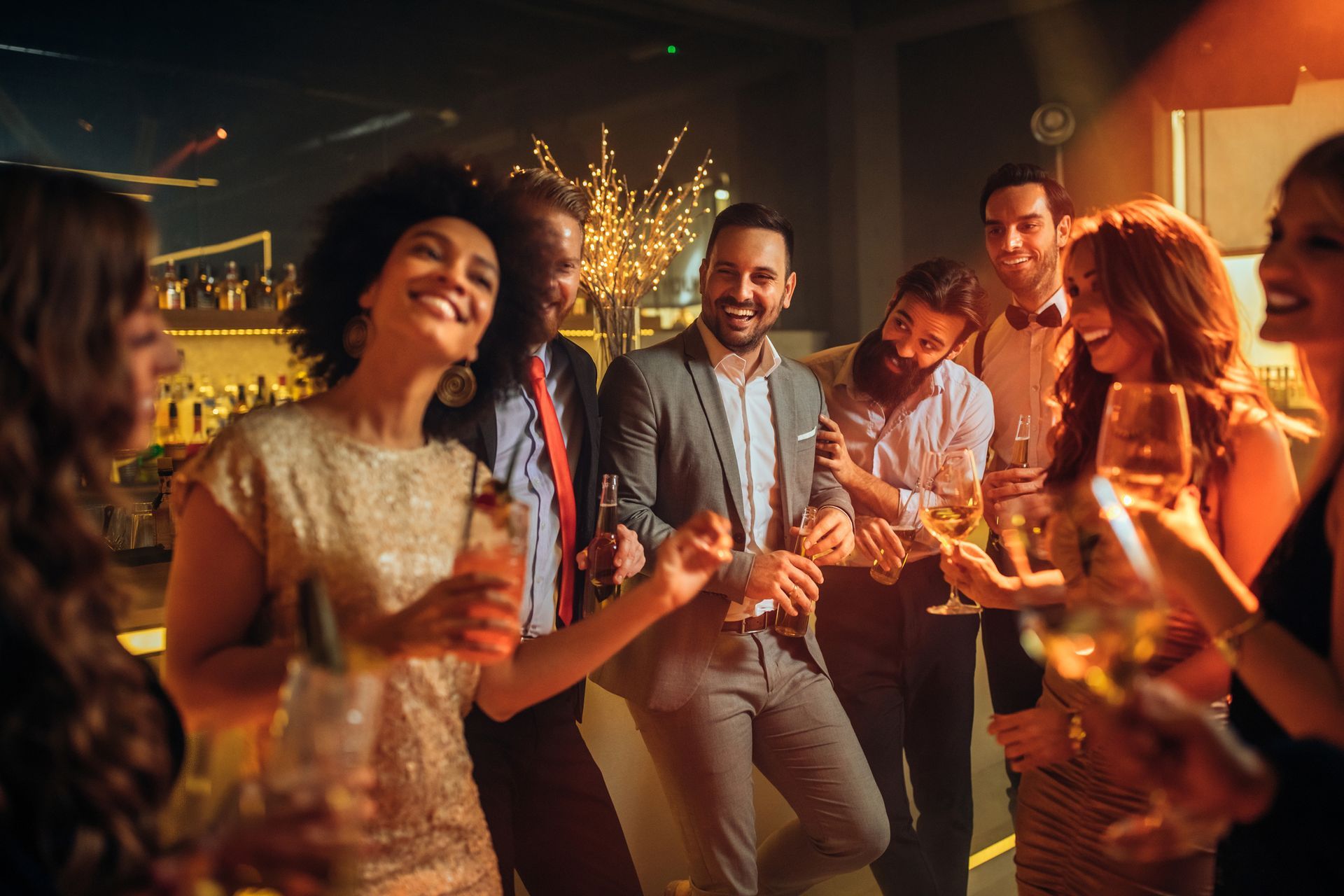 A group of people are dancing and drinking champagne at a party.